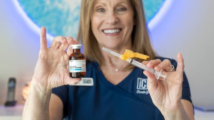 Nurse holding a vitamin shot vial and syringe